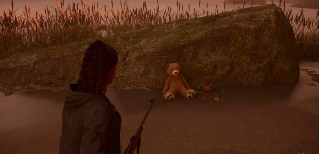 An in game screenshot of a teddy bear on Bunker Woods beach from Alan Wake 2