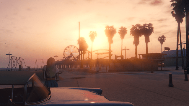 Female character leaning on blue car watching the sunset on Vespucci beach from GTA 5.