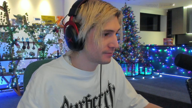 xQc looking at his screen with a neutral expression.
